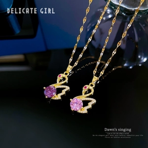 Luxurious swan pendant necklaces in gold with purple and pink crystals on black background