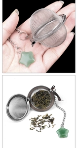 Detail of stainless steel tea infuser with green star pendant and loose tea leaves