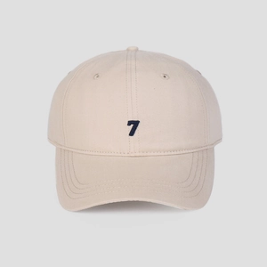 Detail of beige cotton baseball cap with dark blue number 7 embroidery on the front