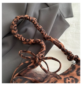 Dettaglio borsa leopardata con manico arricciato e decorazione a fiocco romantico