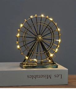 Vintage bronze ferris wheel model with warm LED lights on book for home decor