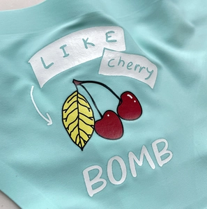 Macro shot of mint green ice silk thong with cherry print and LIKE cherry BOMB text