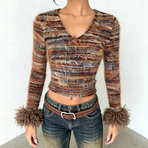 Detailed texture of slim fit V-neck knit top with faux fur cuffs and fuzzy striped yarn