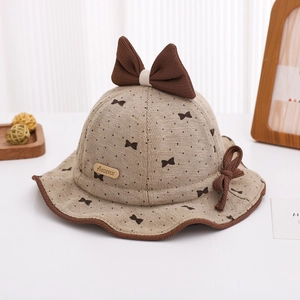 Detailed view of baby sun hat featuring a large brown bow and soft textured knit fabric