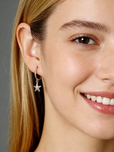 Close-up of a silver S925 sterling silver hoop earring with a starfish pendant on model