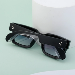 Detail of square black sunglasses frame featuring silver star rivets on the side