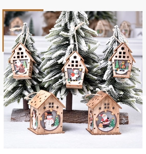 Close-up of wooden glowing Christmas house pendants with festive cutouts and string