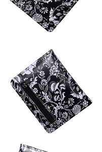 Detail of bat and floral print on faux leather zipper wallet with black hardware