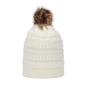 Detail view of winter knitted beanie featuring thick ribbed texture and faux fur pom-pom