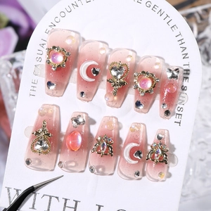 Macro shot of long ballerina press-on nails with pink gradient and luxury crystal rhinestones