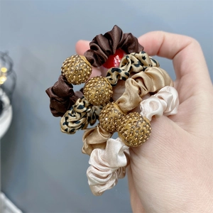 Detail of satin scrunchies featuring leopard prints and rhinestone ball ornaments