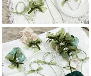 Detail of green silk bow hair scrunchie with lily bell charm and cream elastic ties