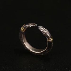 Close-up of retro spearhead ring with silver hammer texture and gold wire details