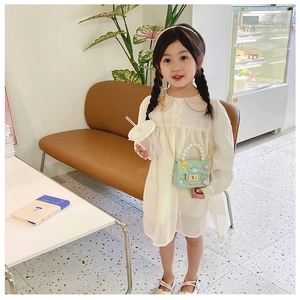 Cute mint green girl's handbag featuring pearl handle and cartoon ocean charms in a cafe