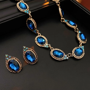 Détail d'une parure vintage avec pierres bleues ovales sur un fond noir élégant