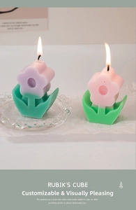 Close-up of lit flower-shaped scented candles in purple and pink gradient colors