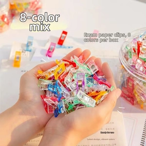 Close-up of hands holding mixed colorful plastic sewing clips for DIY craft and patchwork