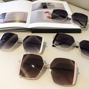 Detail of square geometric sunglasses with gold metal frames in diverse colors on a magazine