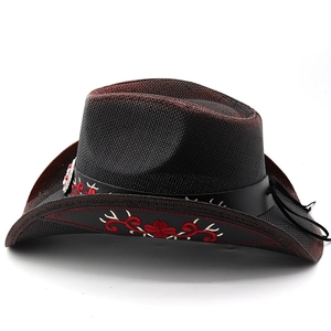 Detail of red floral embroidery on black straw cowboy hat with leather band trim