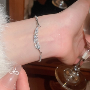 Detailed view of silver feather bracelet with cubic zirconia on a wrist