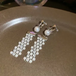 French vintage silver tassel earrings with pearls and crystals on a ceramic plate