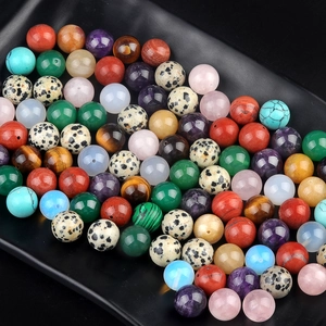 Variety of 12mm half-hole natural stone beads for DIY jewelry making on black tray