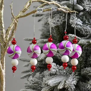 Detailed view of purple spiral candy Christmas ornaments with white glitter and red beads