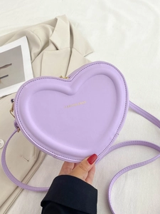 Dettaglio della borsa a tracolla a cuore lavanda con scritte dorate sulla superficie