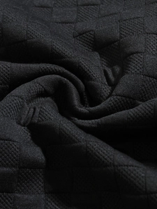 Macro shot of black waffle knit fabric texture on men's slim fit long sleeve shirt