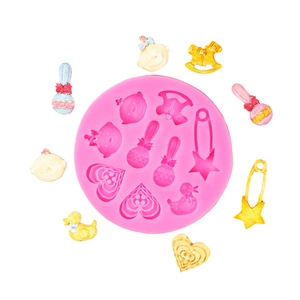 Pink silicone baby mold featuring rocking horse, rattle, and pin for cake decorating fondant