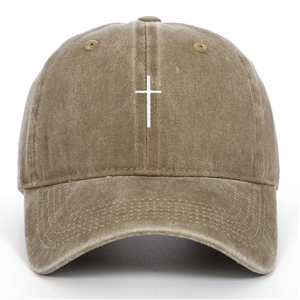 Close-up of a brown washed cotton baseball cap with a white cross embroidery detail