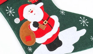 Close-up of linen Christmas stocking featuring embroidered Santa Claus with gift bag