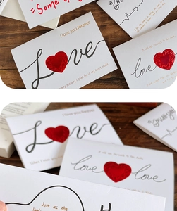 Close-up of 3D pop-up heart greeting cards with red hearts and romantic text on wood