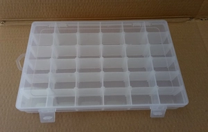 Top-down view of a clear plastic 24-compartment storage box for jewelry and beads