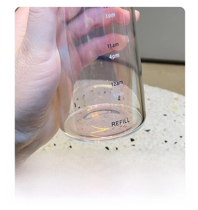 Detailed view of the thickened bottom and time markers on this transparent glass water bottle
