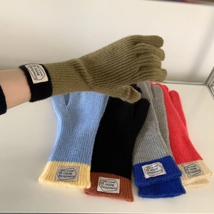 Detail view of colorful color-block knit gloves featuring touch-screen fingertip technology