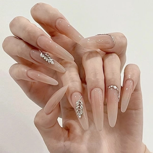 Elegant nude gradient press-on nails with luxury rhinestones shown on hand model