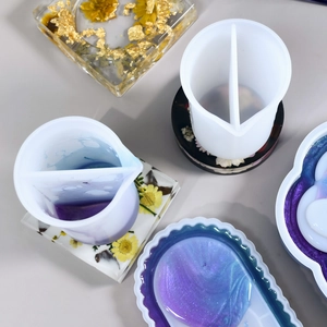 Close-up of dual-chamber silicone split cups for resin art with gold foil and floral coasters