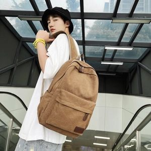 Minimalist light brown canvas backpack featuring leather zipper pulls and front pocket