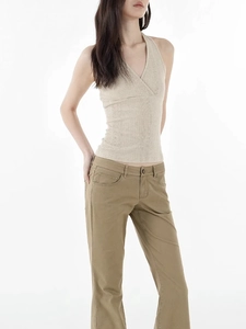 Detailed view of beige ribbed knit texture and cross V-neck halter design on top