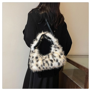 Detailed view of plush leopard print shoulder bag on a model with black leather strap