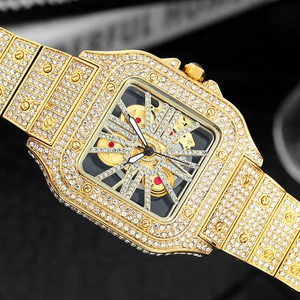 Close-up of gold square watch with iced-out diamonds and hollow skeletal dial design