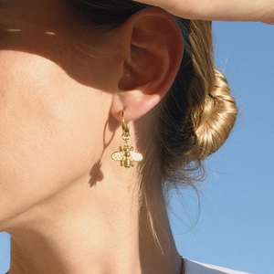Classic 18K gold plated stainless steel bee earrings worn by model with natural shadows