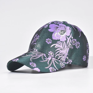 Detailed embroidery of purple floral patterns on dark green silk baseball cap