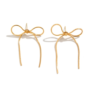 Macro detail of textured gold bow earrings with intricate metallic woven pattern