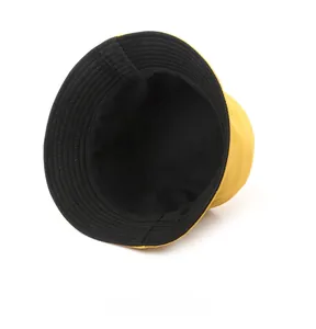 Detail view of double-sided sun hat showing yellow exterior and black interior lining
