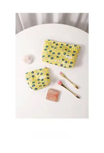 Detailed set of two quilted floral cosmetic bags in bright yellow with metal zippers