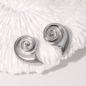 Silver conch shell earrings in high-polished stainless steel on a white coral base