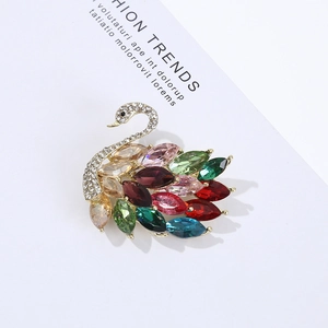 Detailed close-up of a gold swan brooch featuring colorful crystals and vibrant rhinestones