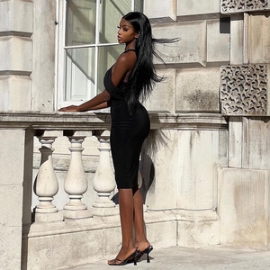 Side view of elegant black midi dress with cutout neck and high-heeled sandals